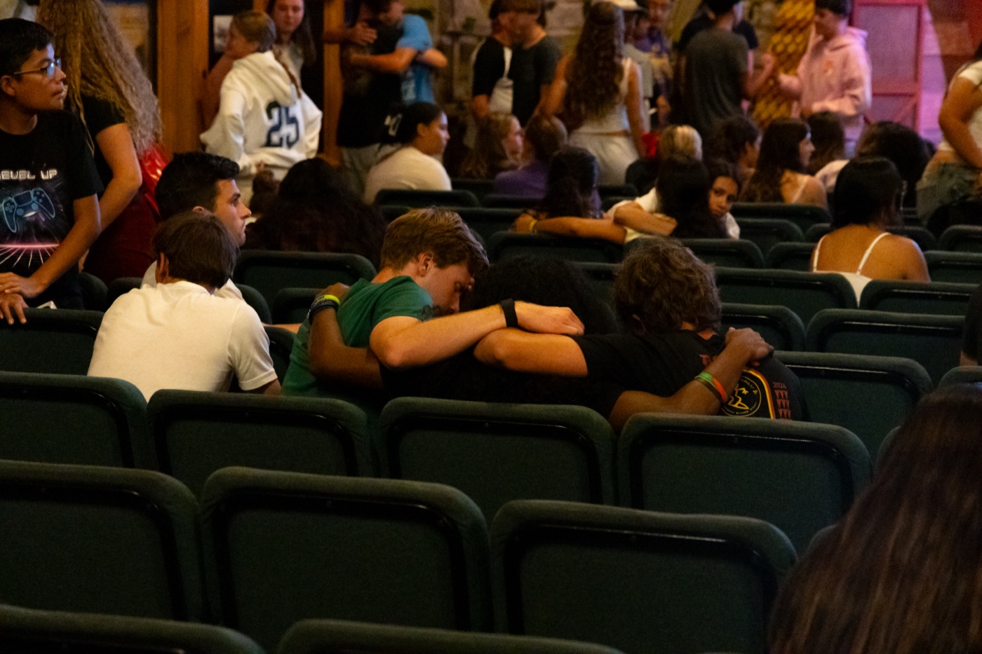 Campers in rows of green chairs during chapel.