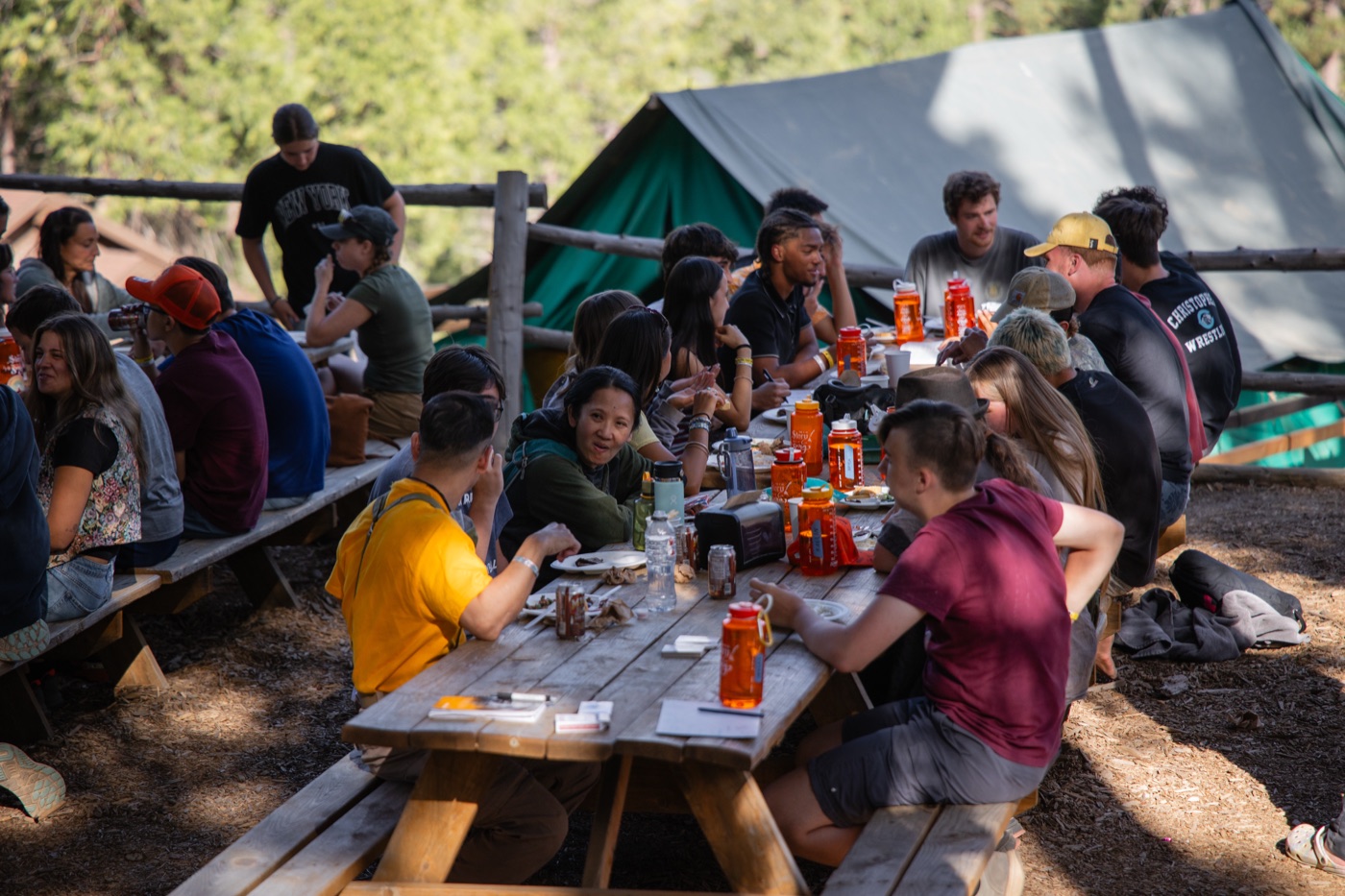 Campers at long tables eating together at Wildwood.
